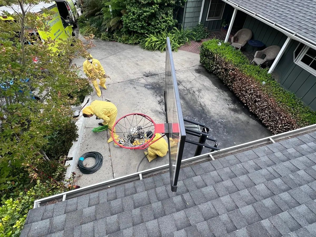 Roofers installing a blue roof tarp