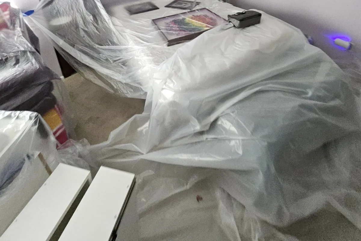 Room covered in plastic sheeting before cleanup