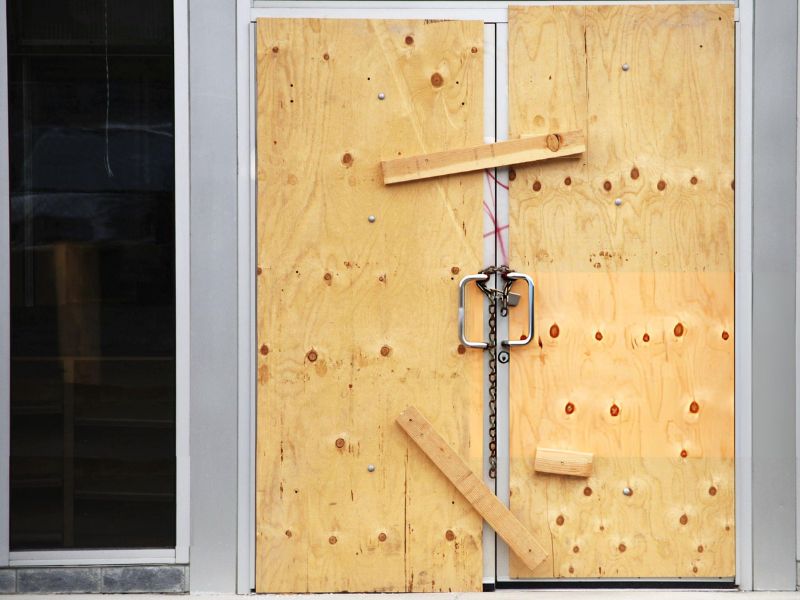 Plywood over doors of closed business - Green Planet Restoration