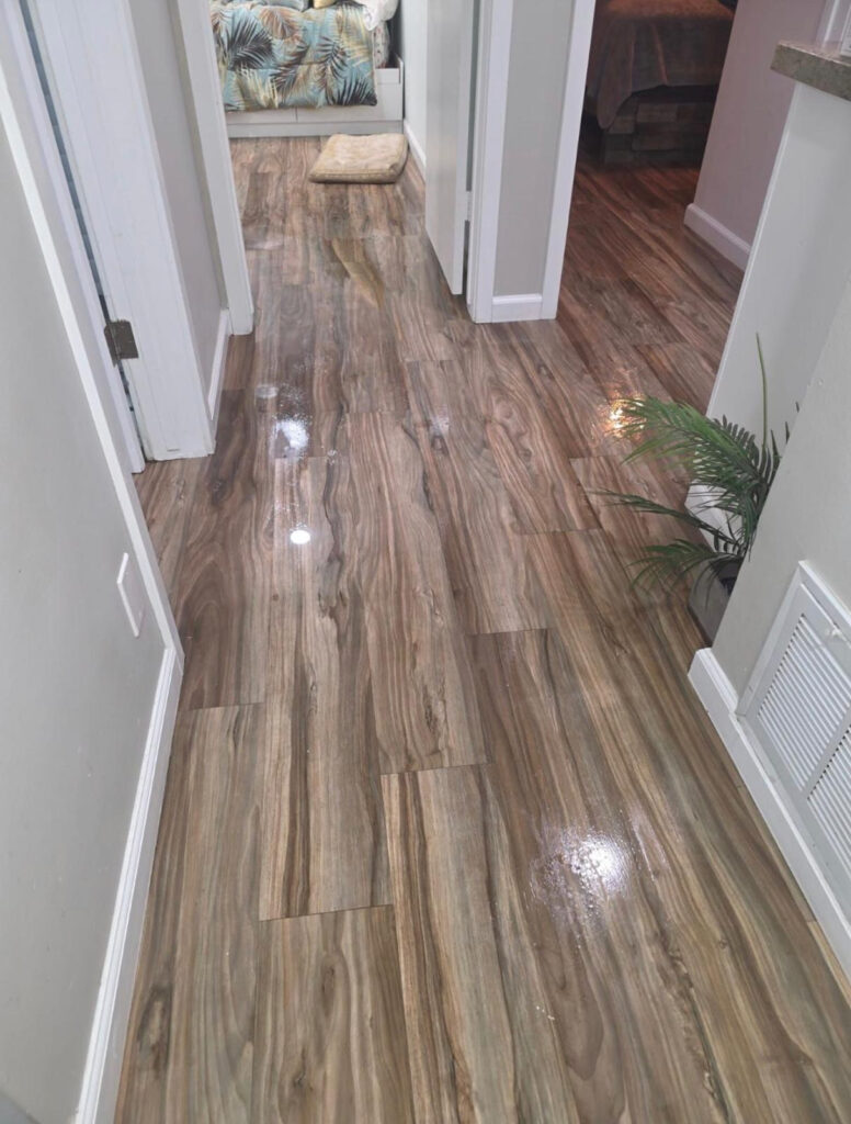 Water spread through hallway flooring at a Long Beach, CA 90808 residence.