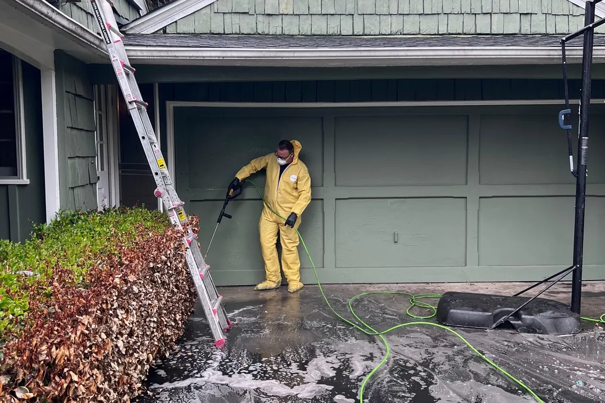Crew washing soot off a home exterior