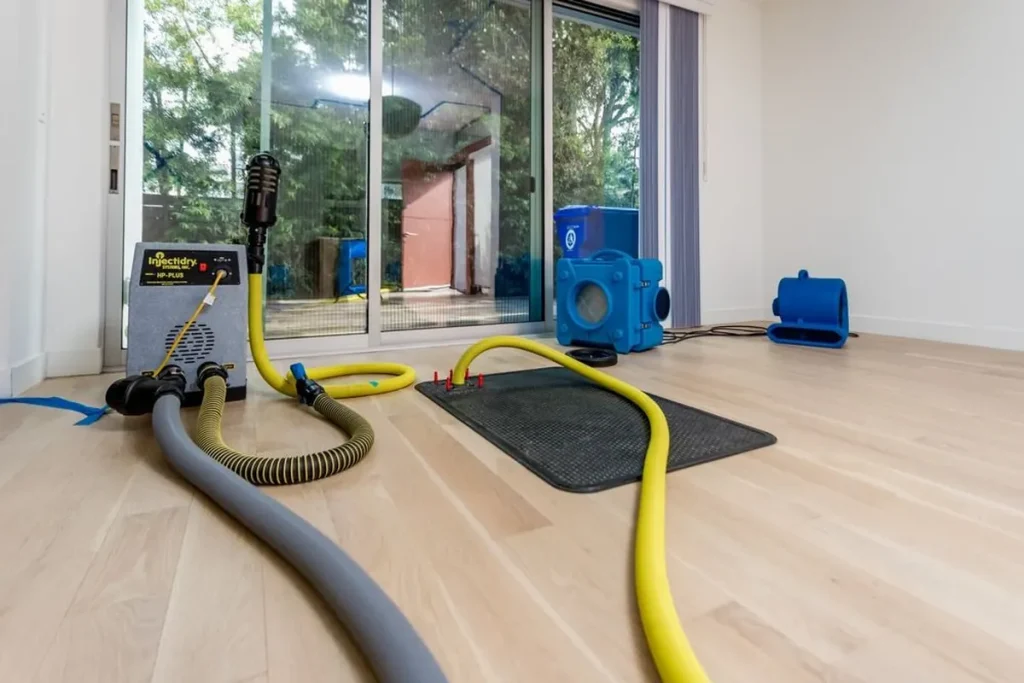 Extraction hoses and air movers on a hardwood floor