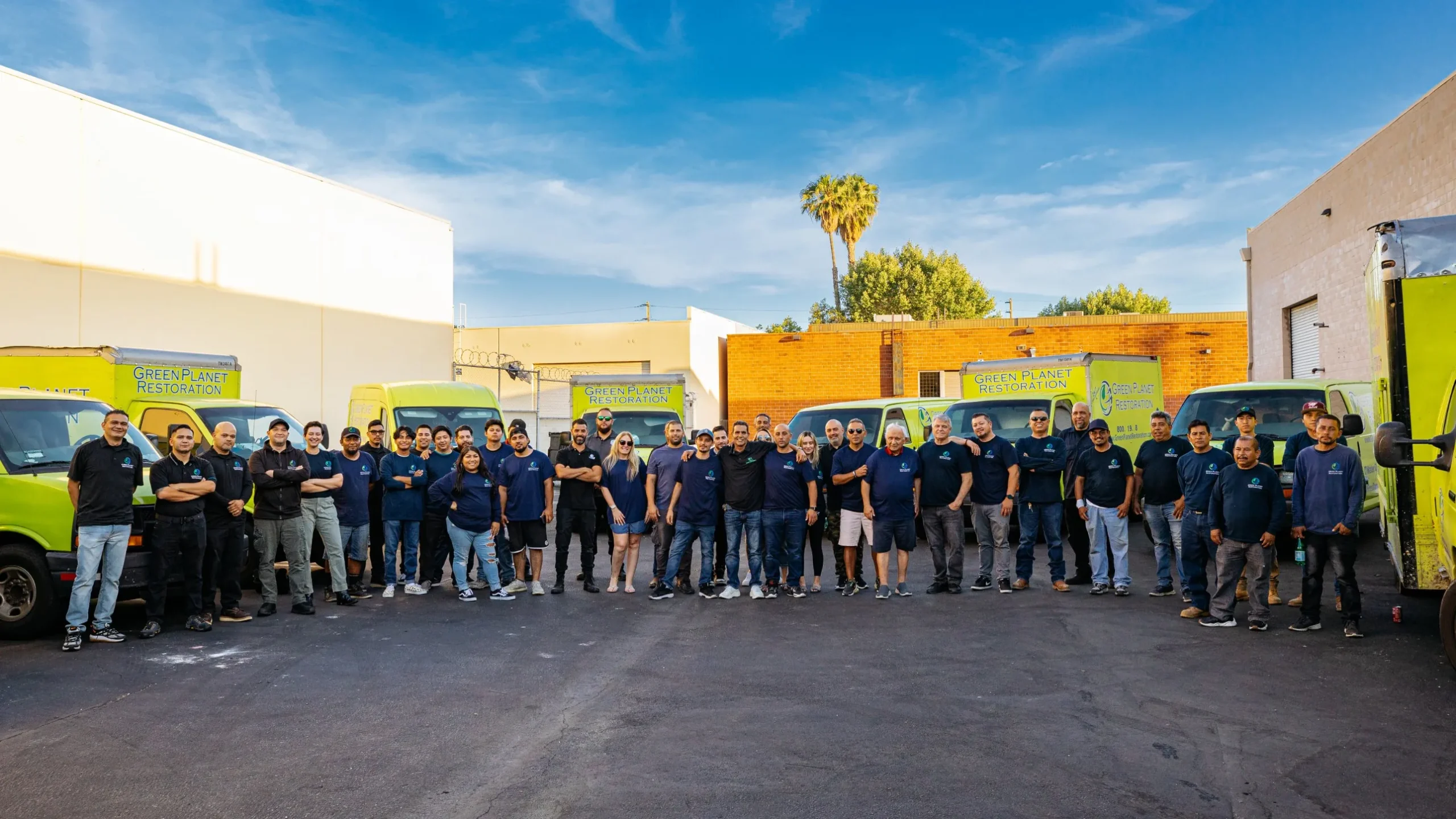 Green Planet Restoration crew celebrating in front of a company truck