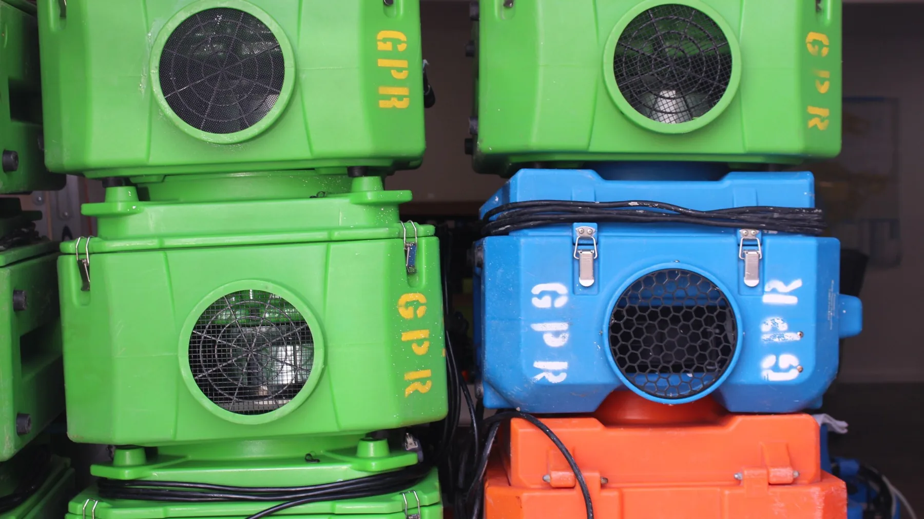 Dehumidifier, HEPA air scrubber, air mover and moisture meters staged on a restoration job